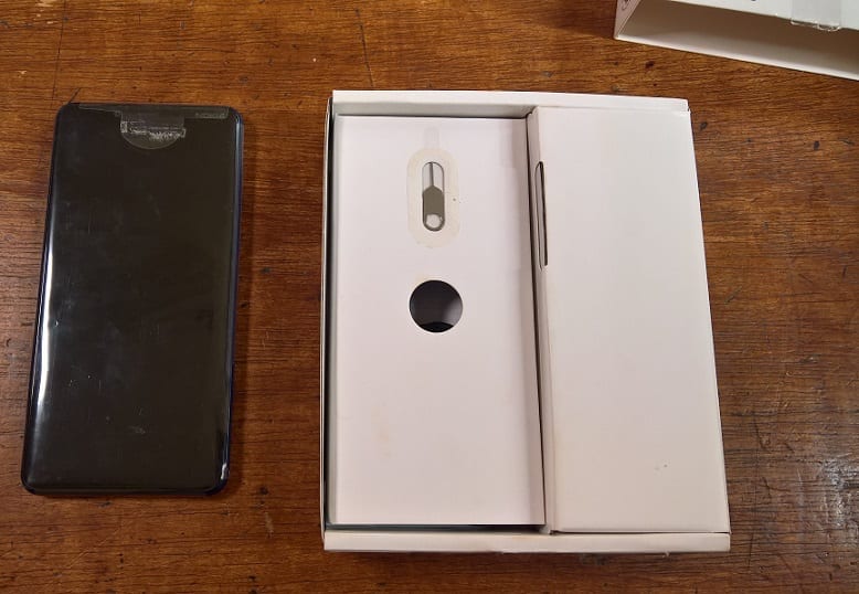 Nokia 3.1 Plus Beside the Box containing the Accessories