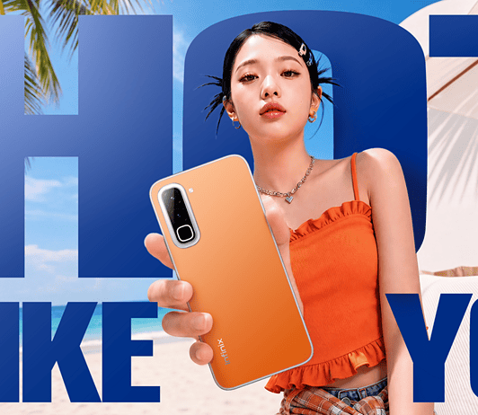 Model holding the Infinix Hot 70 phone on the beach