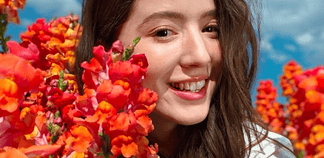Best Portrait Camera Phone with Natural Background Blur in India? The OPPO Find X9 Ultra makes a strong case Photo of a smiling person among vibrant flowers
