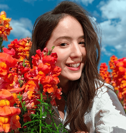Best Portrait Camera Phone with Natural Background Blur in India? The OPPO Find X9 Ultra makes a strong case Photo of a smiling person among vibrant flowers